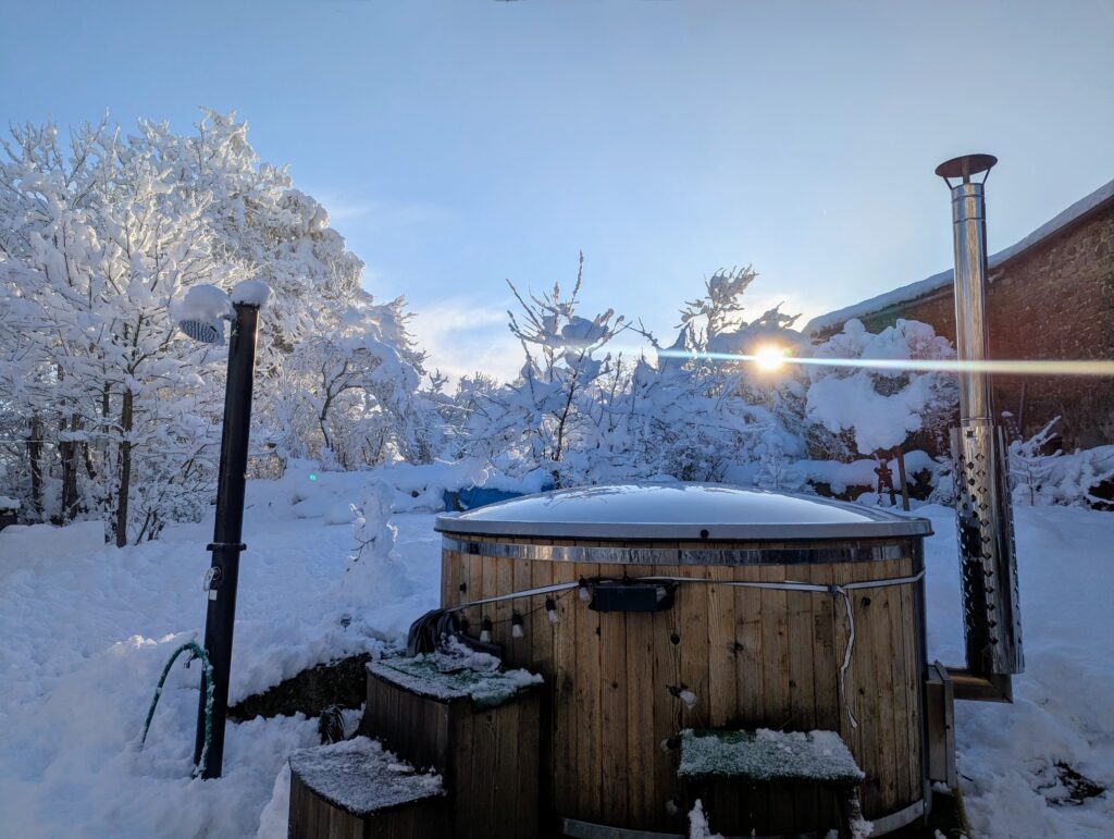 Bain nordique enneigé de notre gîte avec soleil